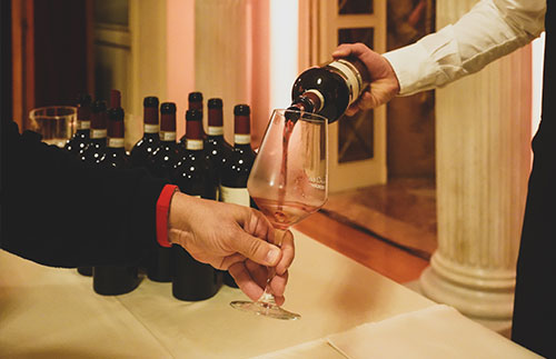 enoteca, sommelier versa bicchiere di vino